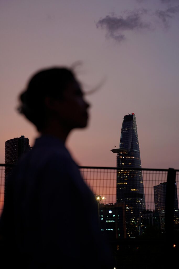 夜景をバックに一人たたずむ女性のシルエット